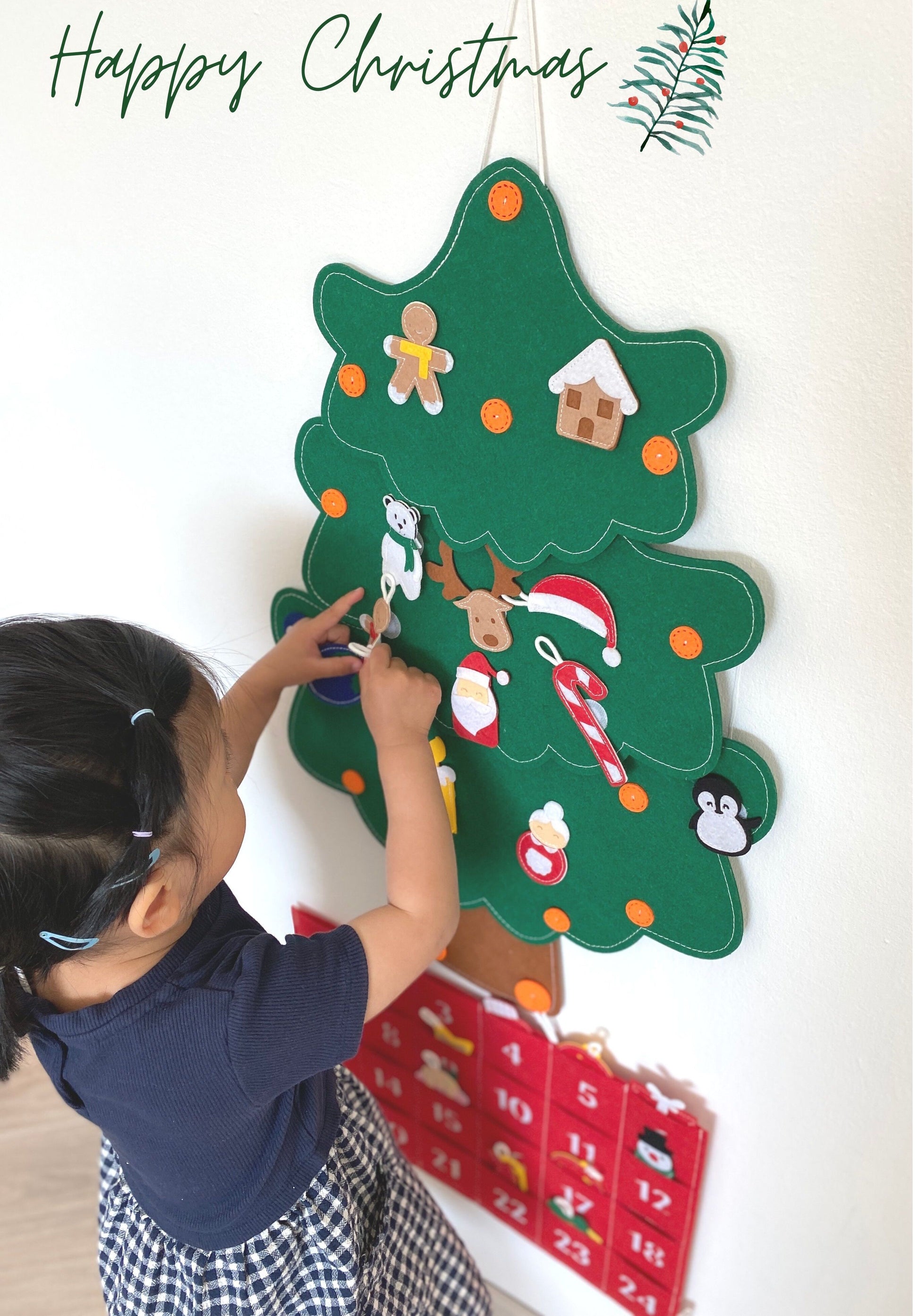 a little girl putting decorations on Weihnachtsbaum mit Adventskalender