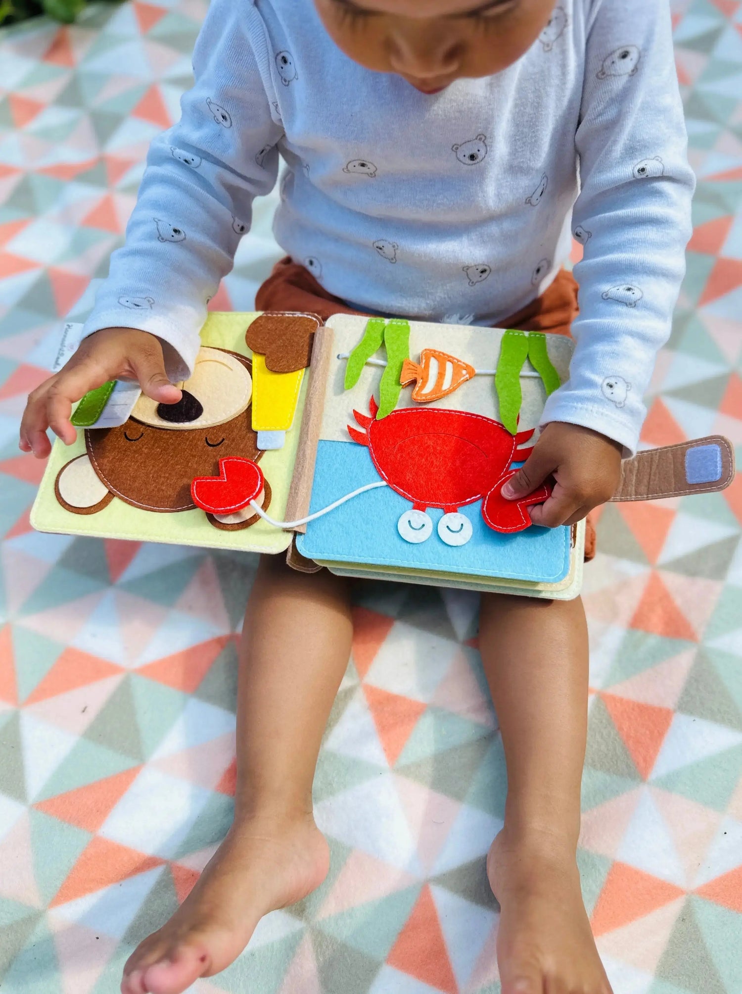 Mini Quiet Book Löwe, Kind spielt auf Decke, Krabben und Bärchen putzt Zähne