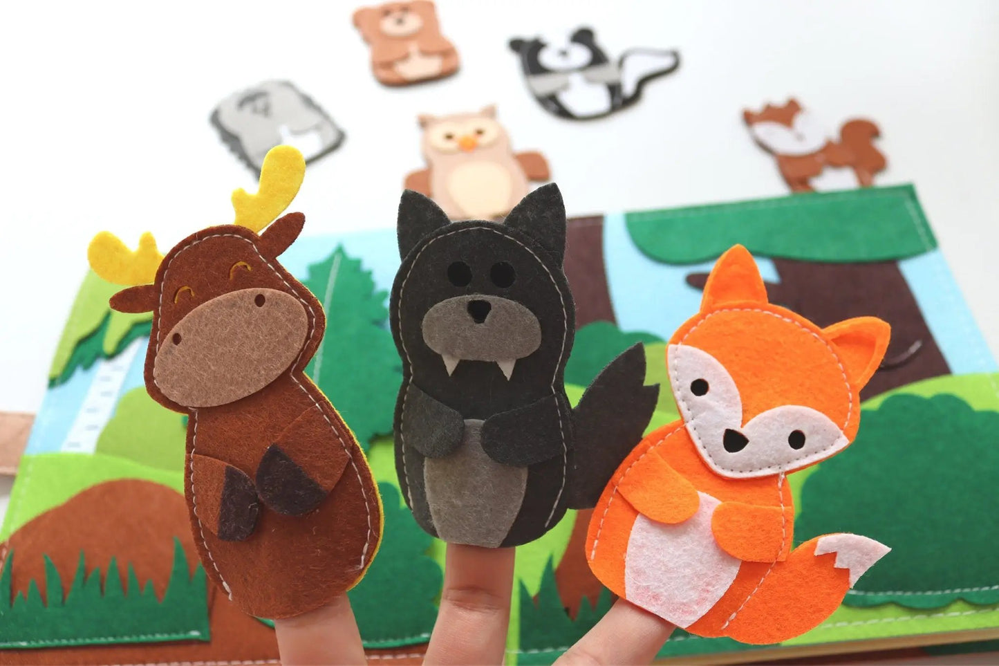 three finger puppets of different animals on a table